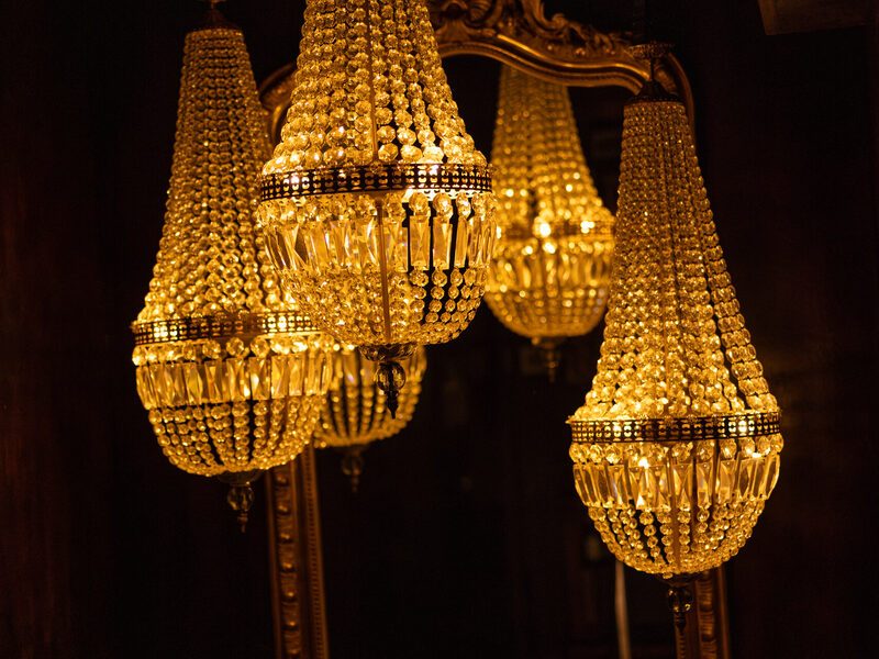 Crystal chandeliers in front of a gilded mirror