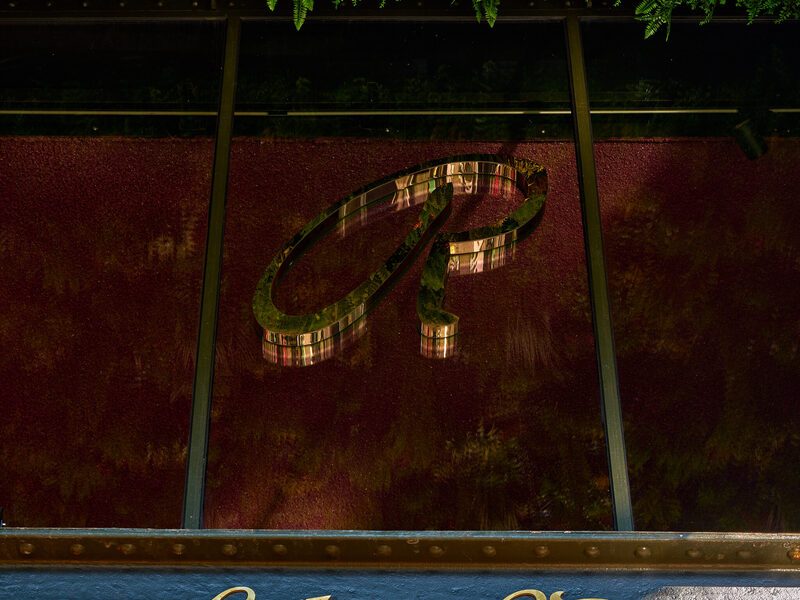 The Chez van Rijn facade: gold lettering on the steel balcony of the De Kroon building