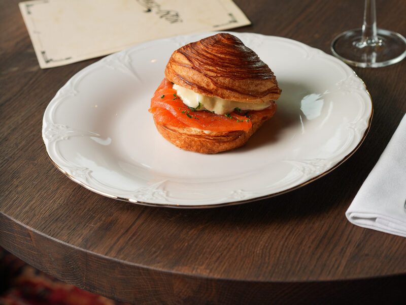 Croissant bun with smoked salmon and a coupe of champagne