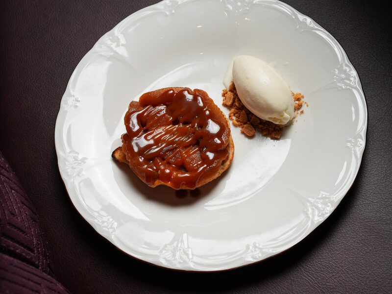 Tarte Tatin with creme fraiche ice cream on white porcelain