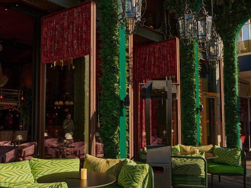 The Chez van Rijn terrace on Rembrandtplein with green lounge sofas and lanterns