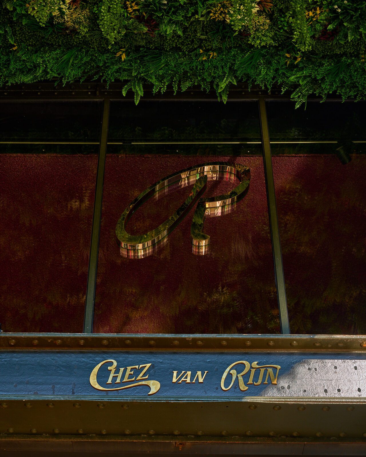 The Chez van Rijn facade: gold lettering on the steel balcony of the De Kroon building