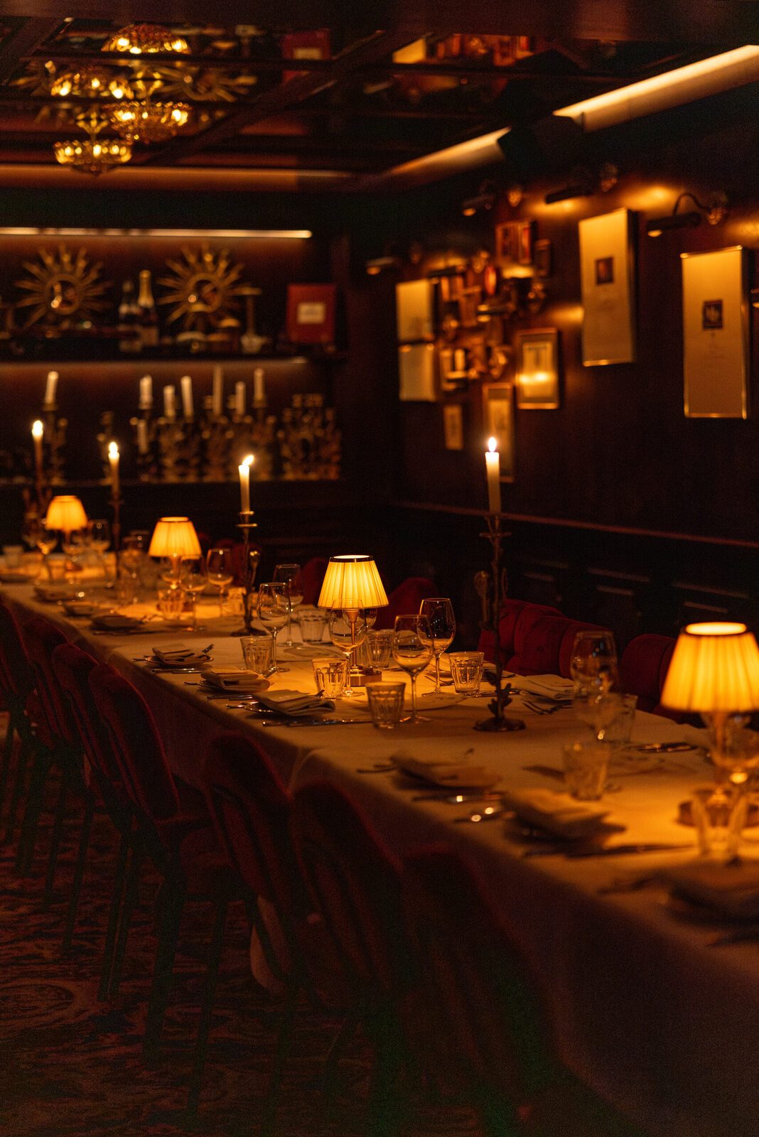 The Private Dining: a long set table with candles and brass lamps