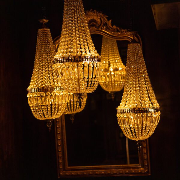 Crystal chandeliers in front of a gilded mirror