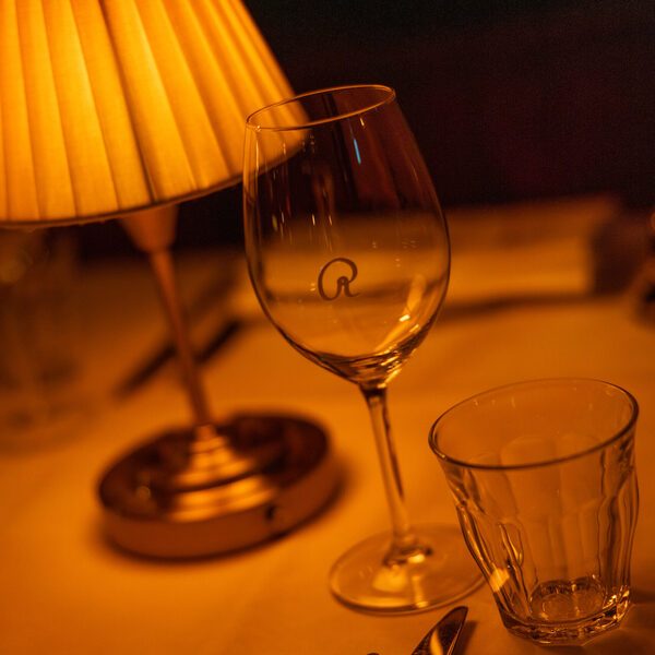 Engraved wine glass with the Van Rijn R by lamplight
